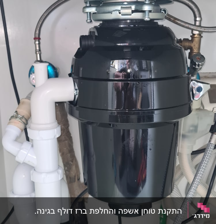 מתקן טוחן אשפה מתחת לכיור עם צינורות מחוברים